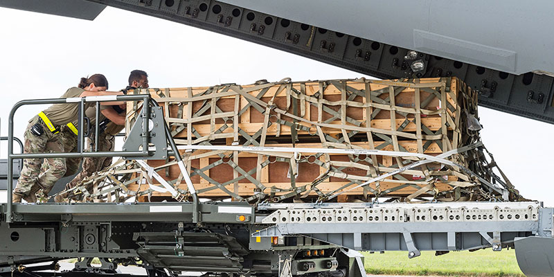 Soldiers loading cargo unto a plane