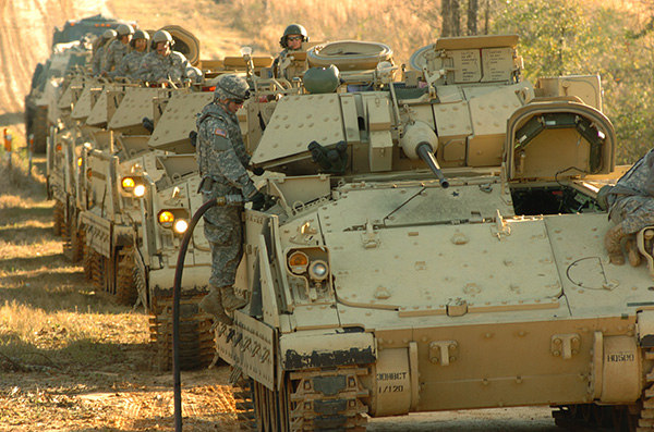 A U.S. Army soldier fuels a Bradley Fighting Vehicle. Soldier fueling a Bradley during field training